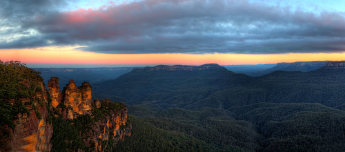 The Late afternoon sun sets in the west casting the final light onto the rock faces of the Three Sisters, Katoomba, NSW, Australia